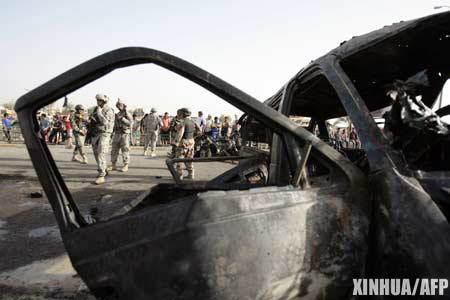 U.S. and Iraqi soldiers secure the site of a car bomb in Baghdad's Al-Shuala neighbourhood. A wave of attacks across Iraq on Sunday killed dozens people, while insurgents bombarded Baghdad's heavily fortified Green Zone with mortar fire, sending U.S. embassy staff scurrying into bunkers.