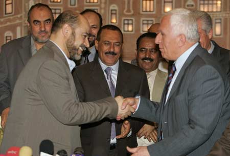 Yemeni President Ali Abdullah Saleh (C in dark suit) looks as Hamas deputy politburo chief Moussa Abu Marzouk (L) and Azzam al-Ahmad, a Fatah leader, shake hands after signing a reconciliation deal between their rival factions at the Presidential Palace in Sanaa March 23, 2008.
