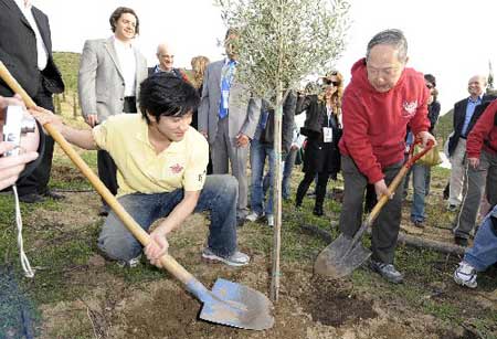 Chinese pop singer Wang Lihong (L) and Liu Hongliang plant a tree in the Coubertin Grove, where modern Games founding father Pierre de Coubertin is buried, in Ancient Olympia, Greece, March 23, 2008. Wang and Liu will be torchbearers in the Greek ralay of the 2008 Beijing Olympic flame. (Xinhua Photo)