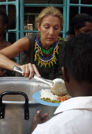 Canadian singer Celine Dion serves up a plate of food during a visit to a school children feeding programme in Soweto township near Johannesburg, February 15 2008. 