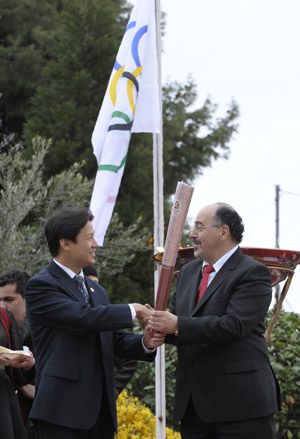 A representative(L) from the Beijing Organizing Committee of Olympic Games (BOCOG) presents a torch to the Mayor of Ioanina during the second day of the torch relay of the Beijing Olympic Games in Ioanina of Greece on March 25, 2008.