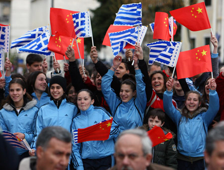 Local residents from Ioanina celebrate the coming of the Olympic flame during the second day of the torch relay of the Beijing Olympic Games in Ioanina of Greece on March 25, 2008.