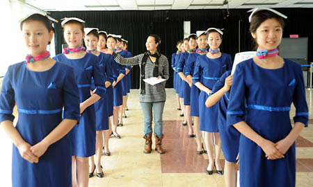 Girls stand with books on their heads during a training in Qingdao, east China's Shandong Province, March 25, 2008. 110 girls selected from 2000 applicants are trained to serve as stewards and ushers for the sailing competition at the 2008 Beijing Olympic Games. 