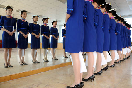 Girls stand in a row in front of a mirror during a training in Qingdao, east China's Shandong Province, March 25, 2008. 110 girls selected from 2000 applicants are trained to serve as stewards and ushers for the sailing competition at the 2008 Beijing Olympic Games. 