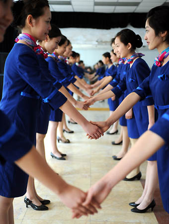 Girls practice shaking hands during a training in Qingdao, east China's Shandong Province, March 25, 2008. 110 girls selected from 2000 applicants are trained to serve as stewards and ushers for the sailing competition at the 2008 Beijing Olympic Games.