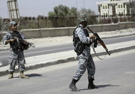 Policemen stand guard on a road in Basra March 25, 2008. Heavy fighting broke out between Iraqi security forces and the Mahdi Army Shiite militia in Basra on Tuesday, a local security source and witnesses said. 