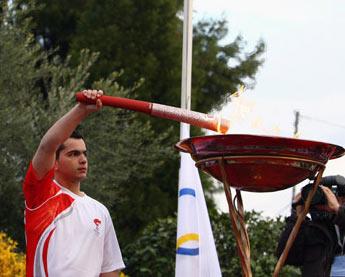 Torchbearer Yiogos from Ioanina kindles the Olympic flame basin with the torch during the second day of the torch relay of the Beijing Olympic Games in Ioanina of Greece on March 25, 2008.  (Xinhua Photo)