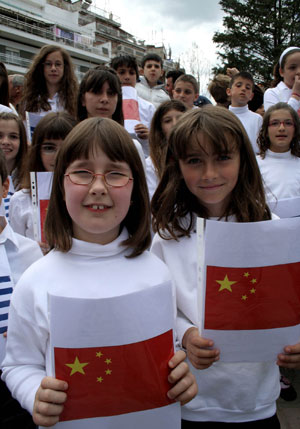 Greek children display Chinese national flags as they wait the arrival of the Olympic flame during the third-day torch relay of the Beijing Olympic Games, in Grevna of Greece on March 26, 2008.