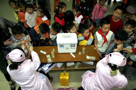 Pupils receive measles vaccination in Gaosheng Experimental Elementary School in Suining, southwest China's Sichuan Province, March 26, 2008. Children aged between eight months and 14 years in 17 cities and prefectures of Sichuan Province receive measles vaccination free of charge on March 25-31. 