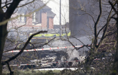 The wreckage of a light aircraft smoulders on a street in Farnborough, north Kent March 30, 2008. Five people are believed to have been on board a private plane that crashed into residential properties near Farnborough in north Kent around 2.30pm on Sunday, police said.