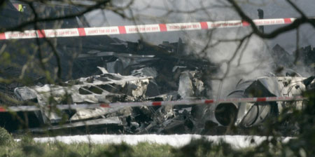 The wreckage of a light aircraft smoulders on a street in Farnborough, north Kent March 30, 2008.