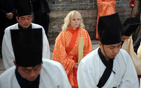 Kong (back,C),daughter-in-law of one of the descendants of Confucius attends a memorial ceremony for Confucius at the Confucius Tomb in Qufu, ancestral home of Confucius, in east China's Shandong Province, March 30, 2008.