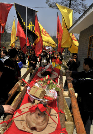 People of the Yi ethnic group carry the sacrifice during the ceremony of worshiping a original flower goddess on the opening of a azalea festival in Qianxi County, southwest China's Guizhou Province, March 28, 2008.