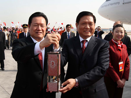Zhou Yongkang (L, front), member of the Standing Committee of the Political Bureau of the Central Committee of the Communist Party of China, and Liu Qi (R, front), president of the Beijing Organizing Committee of the 2008 Olympic Games, hold the lantern with the Olympic flame at the Beijing Capital International Airport in Beijing, capital of China, on March 31, 2008.