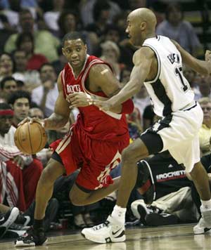 Tracy McGrady(L) of the Houston Rockets drives the ball against Bruce Bowen of the spurs during their NBA basketball game on Sunday. (Photo: sina.com.cn)