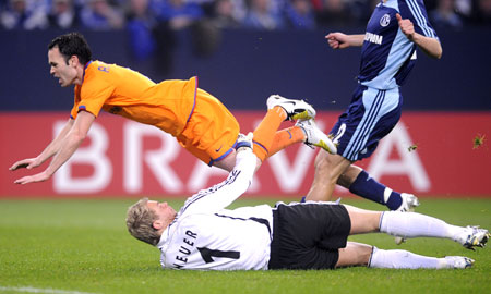 Andres Iniesta (L) of Barcelona is challenged by Schalke 04's goalkeeper during the Champions League quarterfinal first leg soccer match in Gelsenkirchen, April 1, 2008.
