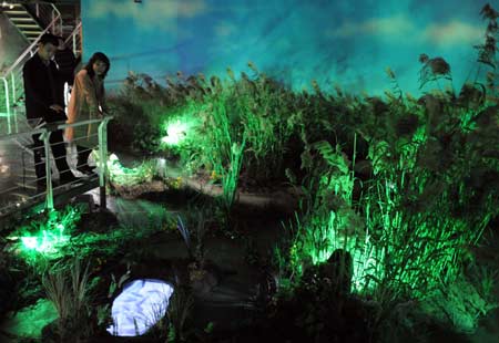 Visitors view vegetation at the wetland museum in Tianjin, north China, March 31, 2008. As wetland covers less and less area in Tianjin, the museum was built and opened to arouse public awareness. 