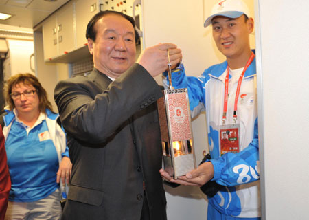 Jiang Xiaoyu (C), the executive vice president of the Beijing Organizing Committee for the 2008 Olympic Games (BOCOG), shows the lantern which holds the Olympic flame in the cabin of the chartered plane at the airport in Istanbul, Turkey, April 3, 2008.(