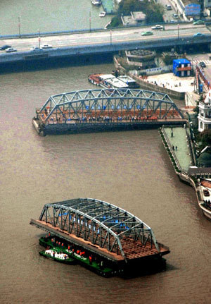 A barge carrying a section of the Waibaidu Bridge sails toward the Huangpu River in Shanghai, east China, April 6, 2008.