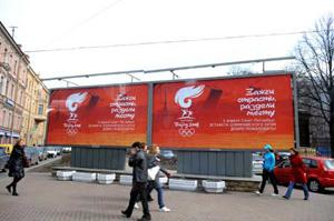 People pass by a notification board for the torch relay ahead of the Olympic torch relay in St. Petersburg, Russia, April 4, 2008. (Xinhua Photo)