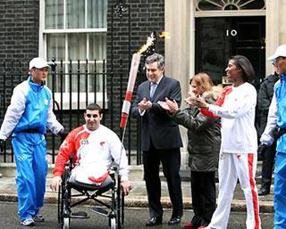 British Prime Minister Gordon Brown (4th L), British Olympic Minister Tessa Jowell and torchbearer Denise Lewis applaud as disabled torchbearer Ali Jawad starts with the torch outside 10 Downing Street in London, capital of Britain, April 6, 2008.(Xinhua Photo)