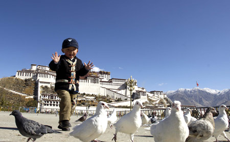 Dainzin, a Tibetean boy, plays with pigeons at the Square in front of the Potala Palace in Lhasa, capital of southwest China's Tibet Autonomous Region, April 7, 2008. Blossom flowers add an odor of spring for the people in and outside the city to enjoy the beautiful scenery. (Xinhua/Purbu Zhaxi)