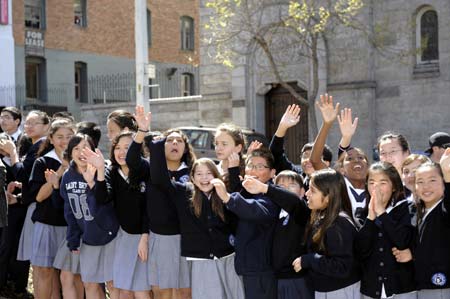 Students of the Saint Brigid School cheer for the Olympic flame on roadside in San Francisco, the United States, April 9, 2008. San Francisco is the sixth stop of the 2008 Beijing Olympic Games torch relay outside the Chinese mainland.