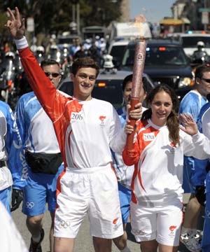 Torchbearers David Drabkin (L) and Lisa Hartmayer run with the torch in San Francisco, the United States, April 9, 2008. San Francisco is the sixth stop of the 2008 Beijing Olympic Games torch relay outside the Chinese mainland.