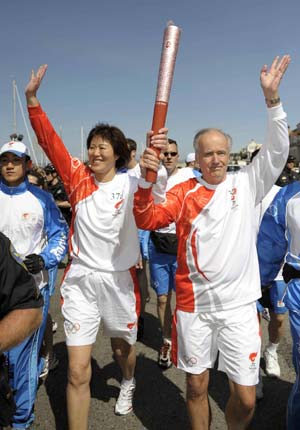 Torchbearer Lang Ping (L), now head of the U.S. women&apos;s volleyball team, and torchbearer James Dolan run with the torch in San Francisco, the United States, April 9, 2008. San Francisco is the sixth stop of the 2008 Beijing Olympic Games torch relay outside the Chinese mainland.
