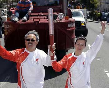 Torchbearer Edwin M. Lee (L), the city administrator of San Francisco, and a female torchbearer run with the torch in San Francisco, the United States, April 9, 2008. San Francisco is the sixth stop of the 2008 Beijing Olympic Games torch relay outside the Chinese mainland. (Xinhua Photo)