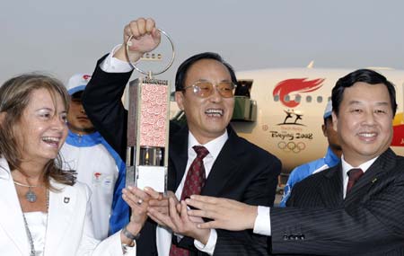 Liu Jingmin (Front, C), the executive vice president of the Beijing Organizing Committee for the 2008 Olympic Games (BOCOG), shows the lantern which holds the Olympic flame with Chinese Ambassador to Argentina Zeng Gang(R) and Argentine Olympic Committee (COA) vice president Alicia Masoni de Morea at the Ezeiza international airport, on the outskirts of Buenos Aires, capital of Argentina, April 10, 2008. Buenos Aires is the seventh leg of the 2008 Beijing Olympic Games torch relay global tour outside the Chinese mainland.