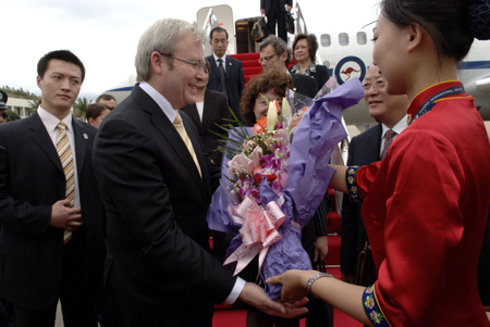 Australian Prime Minister Kevin Rudd (2nd L) receives a bunch of flowers from a girl upon his arrival at the airport in Sanya, south China's Hainan Province, April 11, 2008. 