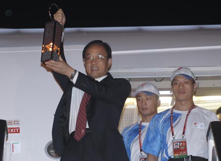 Liu Jingmin (L), the executive vice president of the Beijing Organizing Committee for the 2008 Olympic Games (BOCOG), walks out of the cabin with the lantern which holds the Olympic flame in his hands at the airport in Dar es Salaam, the largest city of Tanzania, April 12, 2008. Dar es Salaam is the eighth leg of the 2008 Beijing Olympic Games torch relay global tour outside the Chinese mainland.