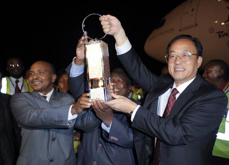 Liu Jingmin (R), the executive vice president of the Beijing Organizing Committee for the 2008 Olympic Games (BOCOG), shows the lantern which holds the Olympic flame with the Tanzanian Minister of Information, Culture and Sports Geoge Mkuchika (C) and Dar es Salaam City Mayor Adam Kimbisa at the airport in Dar es Salaam, the largest city of Tanzania, April 12, 2008. 