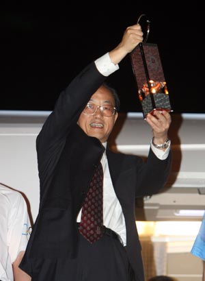 Liu Jingmin, the executive vice president of the Beijing Organizing Committee for the 2008 Olympic Games (BOCOG), walks out of the cabin with the lantern which holds the Olympic flame in his hands at the airport in Dar es Salaam, the largest city of Tanzania, April 12, 2008. 