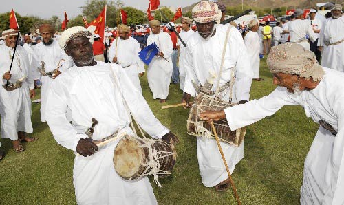 Photo: Local people play Omani folk dance to welcome the flame