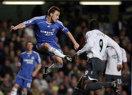 Chelsea's John Terry (L) clears the ball past Wigan Athletic's Emile Heskey during their English Premier League soccer match at Stamford Bridge in London April 14, 2008. 