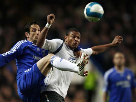 Chelsea's Juliano Belletti (L) challenges Wigan Athletic's Marcus Bent during their English Premier League soccer match at Stamford Bridge in London April 14, 2008. 