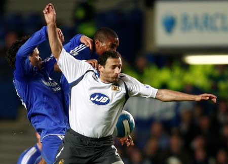 Chelsea's Michael Ballack (L) and team mate Florent Malouda (C) challenge Wigan Athletic's Jospi Skoko during their English Premier League soccer match at Stamford Bridge in London April 14, 2008.