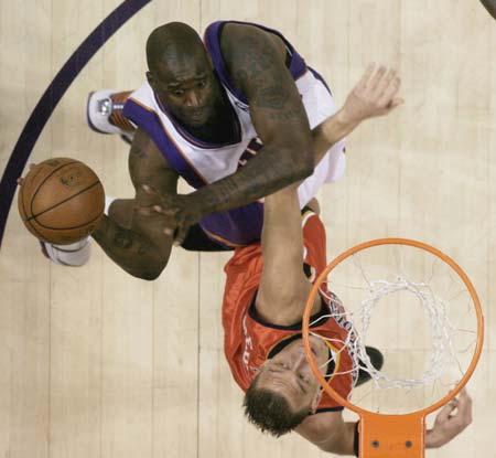 Phoenix Suns' Shaquille O'Neal (L) shoots over the Golden State Warriors' Andris Biedrins during first quarter NBA basketball action in Phoenix, Arizona, April 14, 2008.