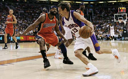 Phoenix Suns Steve Nash (13) drives to the basket while being guarded by the Golden State Warriors Baron Davis (5) during first quarter NBA basketball action in Phoenix, Arizona, April 14, 2008. 