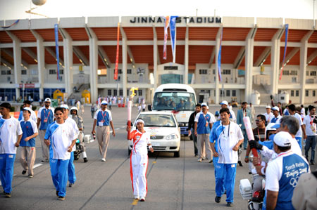 Torchbearer Raheela Bano (C) runs with the torch during the 2008 Beijing Olympic Games torch realy in Islamabad, capital of Pakistan, on April 16, 2008.