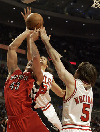 Toronto Raptors forward Kris Humphries (L) goes up for a shot against Chicago Bulls forwards Joakim Noah (C) and Andres Nocioni in the second quarter of their NBA basketball game in Chicago April 16, 2008.