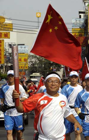 Torchbearer Wlchal Surlyut runs with the torch in Bangkok, capital of Thailand, on April 19, 2008. Bangkok is the 12th stop of the 2008 Beijing Olympic Games torch relay outside the Chinese mainland. (Xinhua/Qi Heng) 