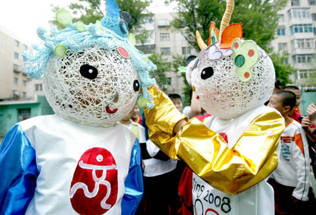 Pupils of the Second Guangrong Primary School show the Beijing Olympic Mascots Fuwa made of paper and ropes in Shenyang, capital of northeast China's Liaoning Province, April 21, 2008. 