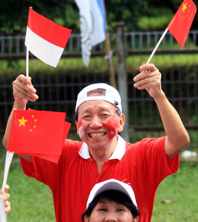 People wave flags to cheer for the Olympic torch relay in Jakarta, capital of Indonesia, on April 22, 2008. Jakarta is the 14th stop of the 2008 Beijing Olympic Games torch relay.