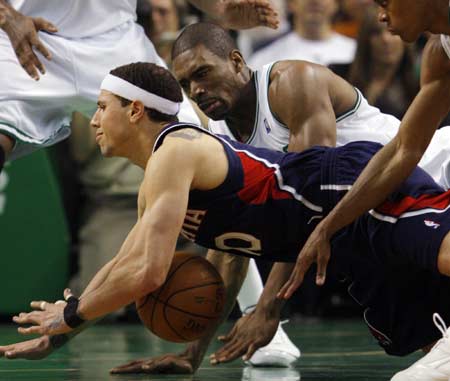 Atlanta Hawks guard Mike Bibby (L) and Boston Celtics forward Leon Powe dive after a loose ball during the second quarter of Game 2 of their NBA basketball playoff series in Boston, Massachusetts April 23, 2008.