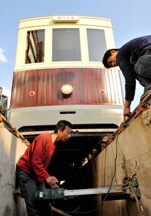 Workers check up the rail for the trolley car on Qianmen Street in Beijing on April 23, 2008.