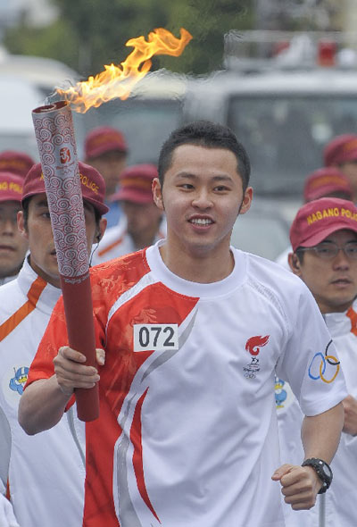 Photo: Japanese swimmer Kosuke Kitajima runs with the torch