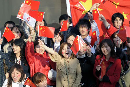 Photo: People along the streets in Nagano hail the flame